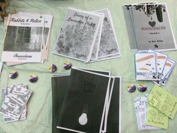 photo of a table covered with black and white zines and badges