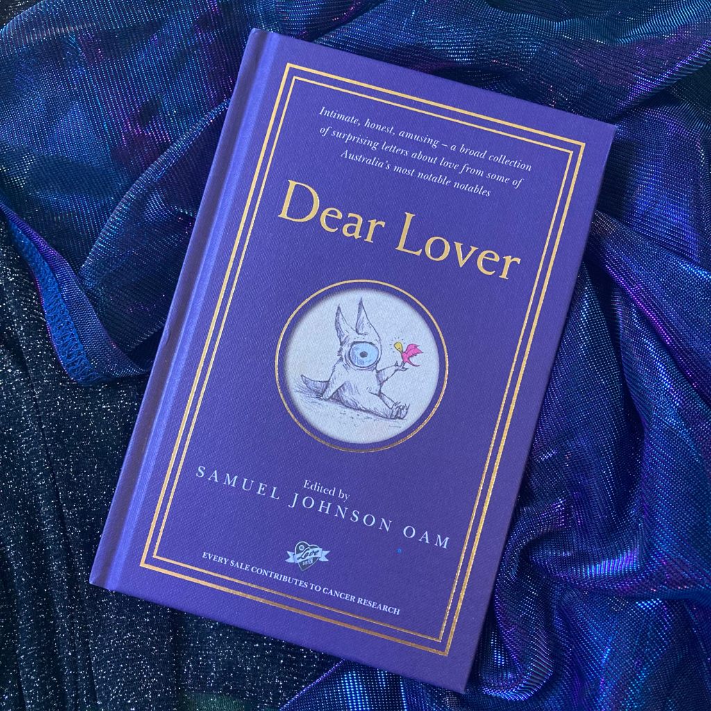 Photo of a purple coloured book with the text: ‘Intimate, honest, amusing - a broad collection of surprising letters about love from some of Australia's most notable notables. Dear Lover. Edited by SAMUEL JOHNSON OAM. EVERY SALE CONTRIBUTES TO CANCER RESEARCH.’